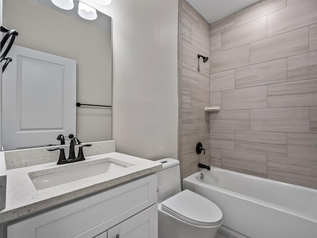 full bathroom with vanity, tiled shower / bath combo, and toilet