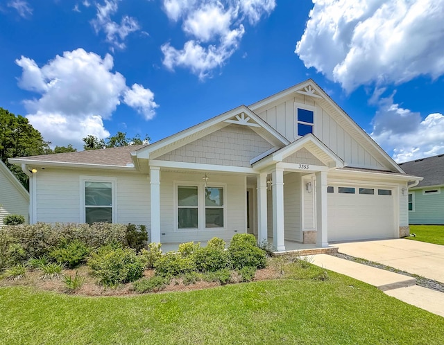 3353 Jasmine Hill Rd, Tallahassee, FL 32311 - view of front of property featuring a front yard, driveway, covered porch, a garage, and board and batten siding