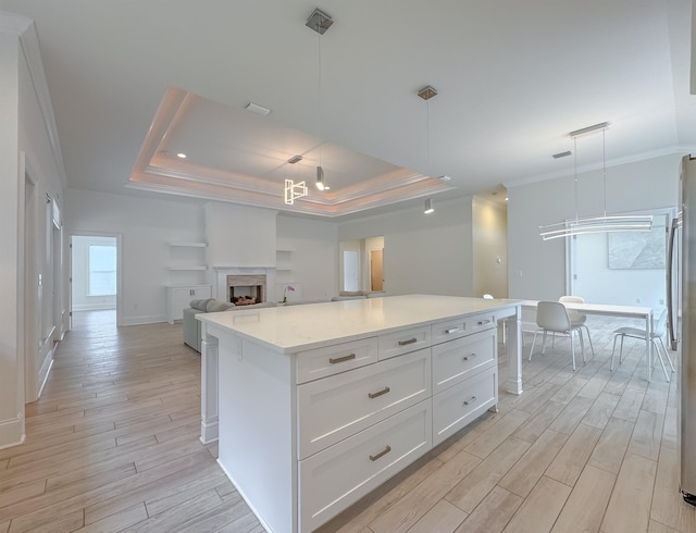 3353 Jasmine Hill Rd, Tallahassee, FL 32311 - kitchen with light wood finished floors, ornamental molding, a raised ceiling, white cabinetry, and open floor plan