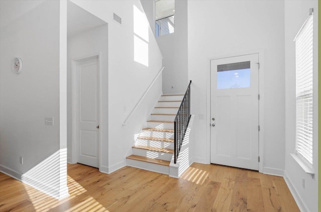 foyer with a high ceiling and light wood-type flooring