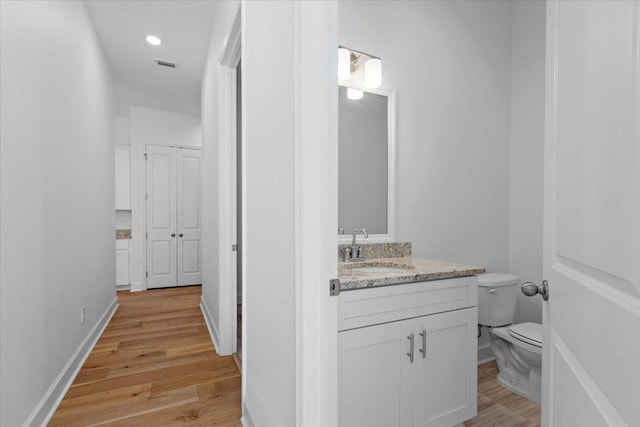 bathroom featuring vanity, toilet, and wood-type flooring