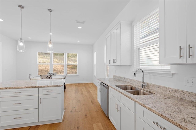 kitchen featuring sink, white cabinetry, light stone counters, decorative light fixtures, and stainless steel dishwasher