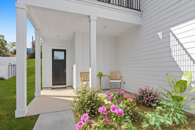 doorway to property featuring a yard and covered porch