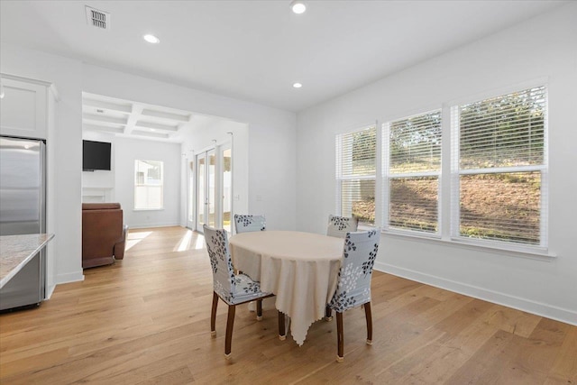 dining room featuring beamed ceiling, coffered ceiling, and light wood-type flooring