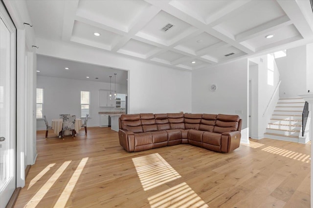 living room featuring coffered ceiling, beam ceiling, and light wood-type flooring