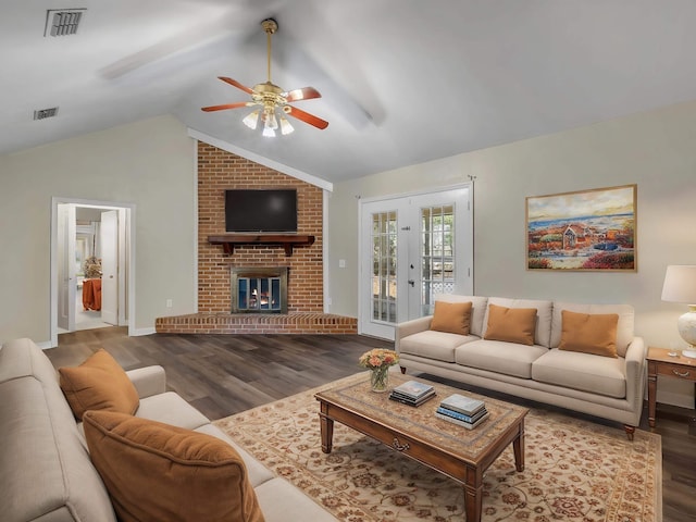 living room with hardwood / wood-style flooring, ceiling fan, vaulted ceiling, and a fireplace