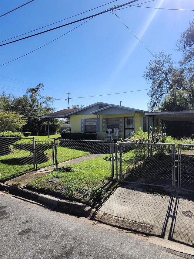 view of front of home with a front yard and a carport