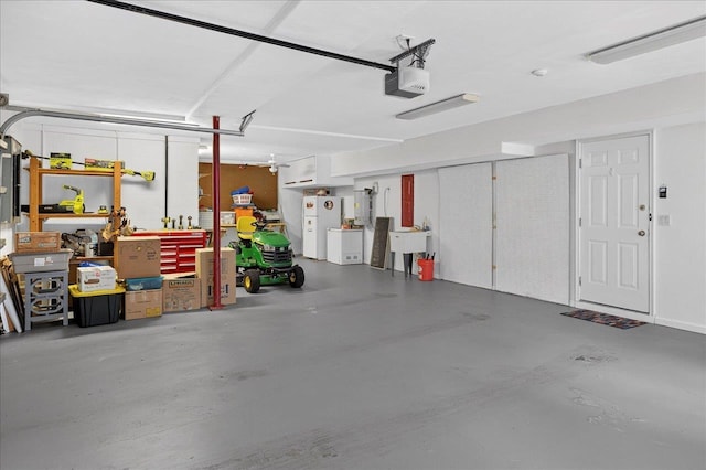 3508 Trillium Ct, Tallahassee, FL 32312 - garage featuring freestanding refrigerator, a garage door opener, and a workshop area