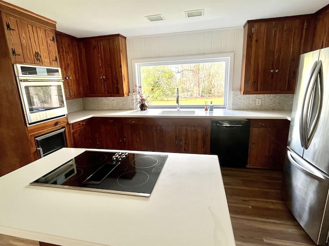 kitchen featuring tasteful backsplash, sink, dark hardwood / wood-style floors, and black appliances