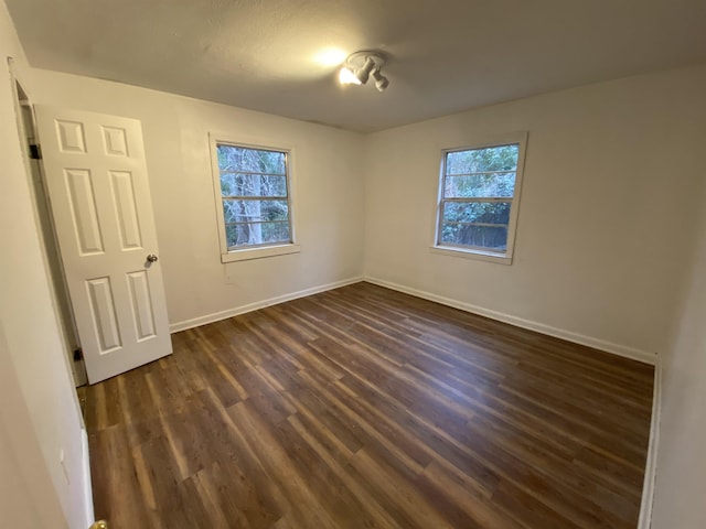 unfurnished bedroom with dark hardwood / wood-style flooring