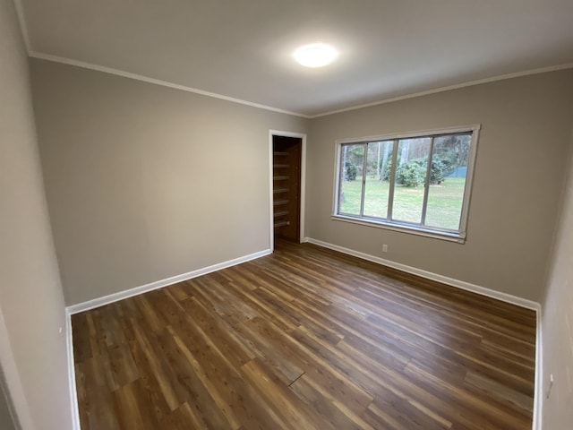 unfurnished room with ornamental molding and dark hardwood / wood-style flooring