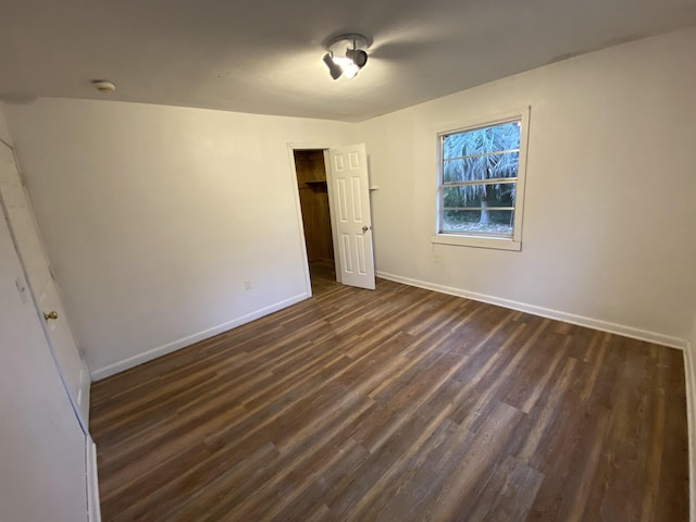 unfurnished bedroom with dark wood-type flooring and a closet