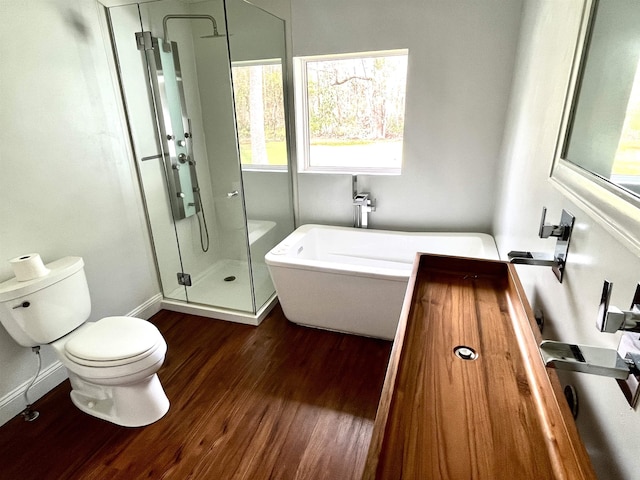 bathroom with wood-type flooring, separate shower and tub, and toilet