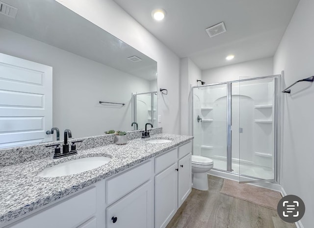 bathroom featuring vanity, hardwood / wood-style floors, toilet, and walk in shower