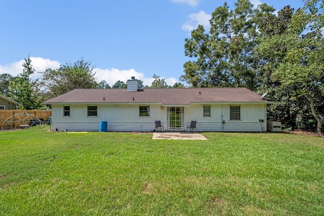 rear view of property featuring a lawn and a patio