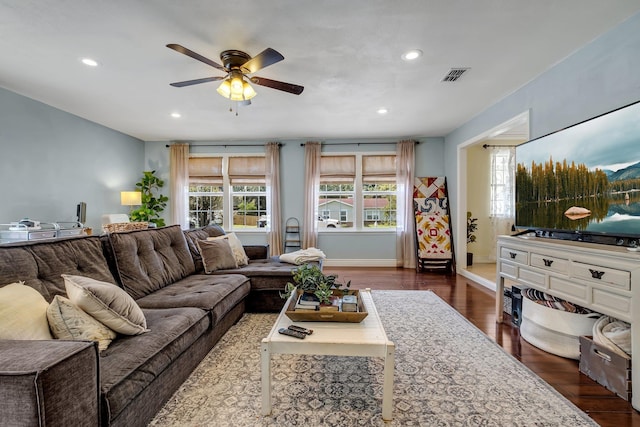 living room featuring ceiling fan and dark hardwood / wood-style flooring