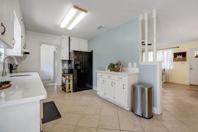 kitchen with black fridge with ice dispenser, white cabinetry, sink, and light tile patterned floors