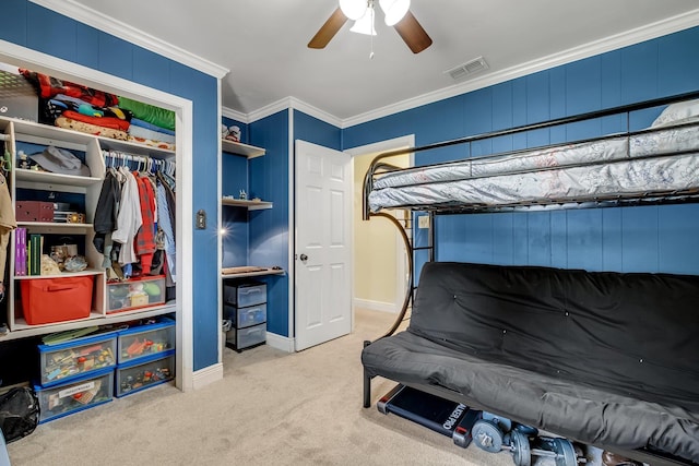 carpeted bedroom featuring a closet, ceiling fan, and crown molding