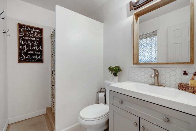 bathroom with backsplash, tile patterned flooring, vanity, and toilet