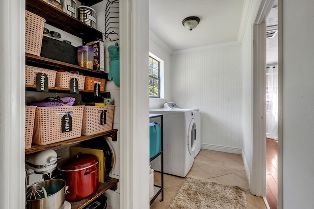 clothes washing area featuring independent washer and dryer, light tile patterned floors, and ornamental molding