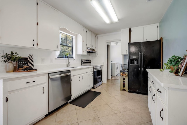 kitchen with appliances with stainless steel finishes, sink, independent washer and dryer, white cabinetry, and light tile patterned flooring