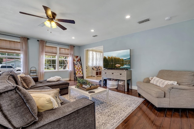 living room featuring ceiling fan and dark wood-type flooring