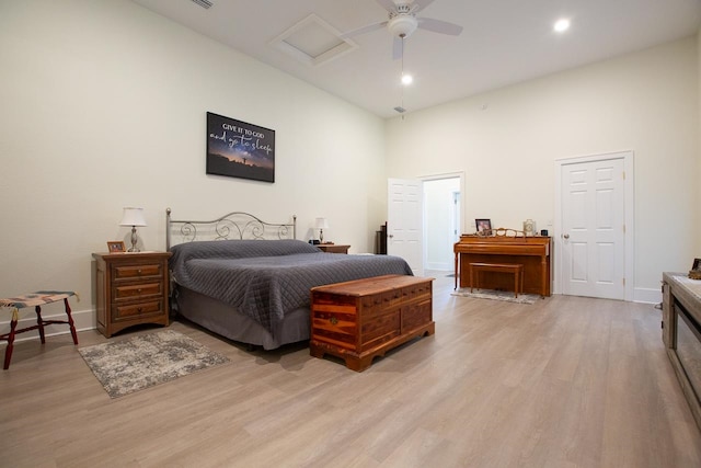 bedroom featuring a high ceiling, light hardwood / wood-style floors, and ceiling fan