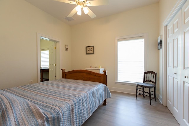 bedroom with dark wood-type flooring, ceiling fan, and a closet