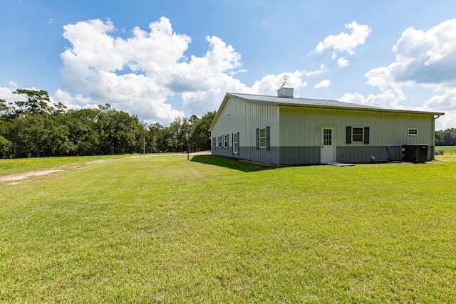 view of home's exterior with central AC unit and a yard