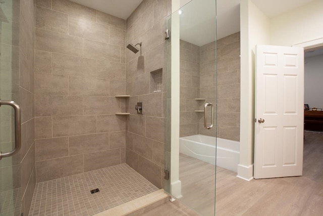 bathroom with hardwood / wood-style flooring and separate shower and tub