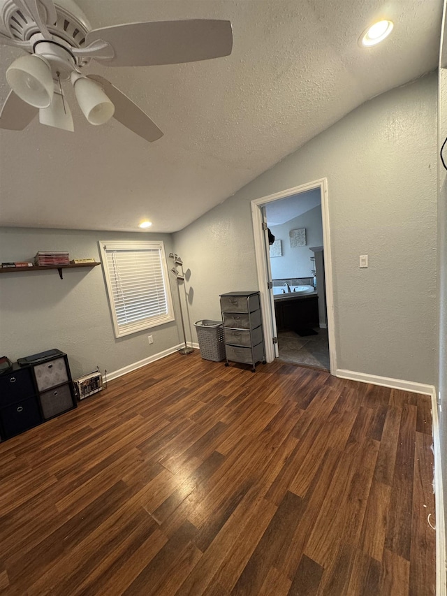 unfurnished bedroom with ceiling fan, dark hardwood / wood-style floors, a textured ceiling, and lofted ceiling