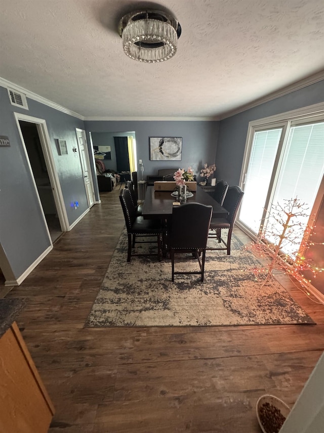 dining area with a textured ceiling, crown molding, and dark hardwood / wood-style flooring