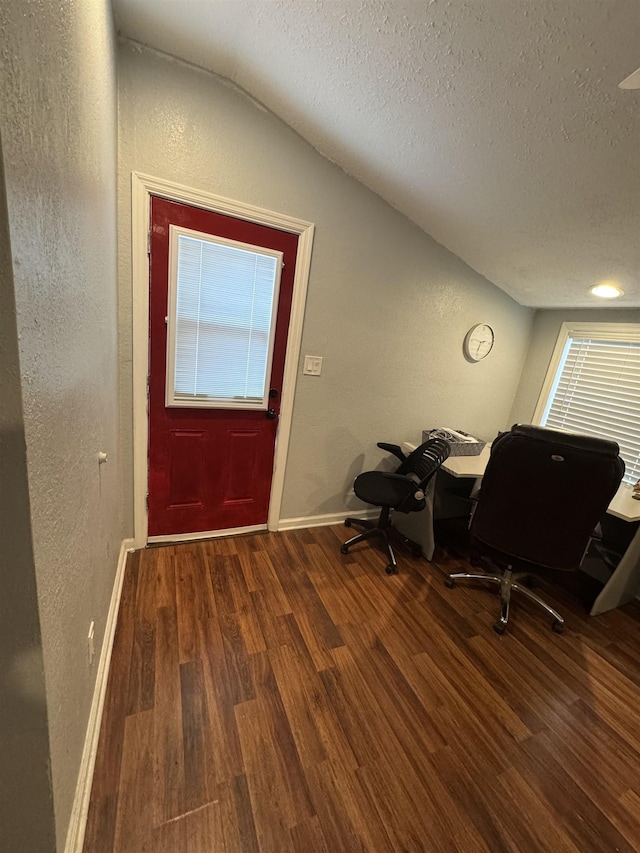 entryway with a textured ceiling, hardwood / wood-style flooring, and lofted ceiling