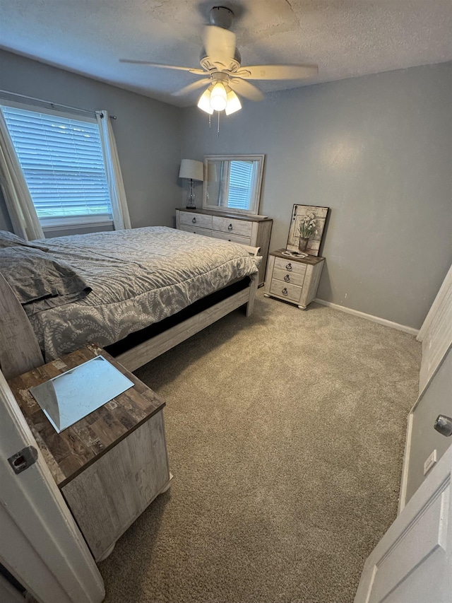 bedroom featuring multiple windows, ceiling fan, carpet floors, and a textured ceiling