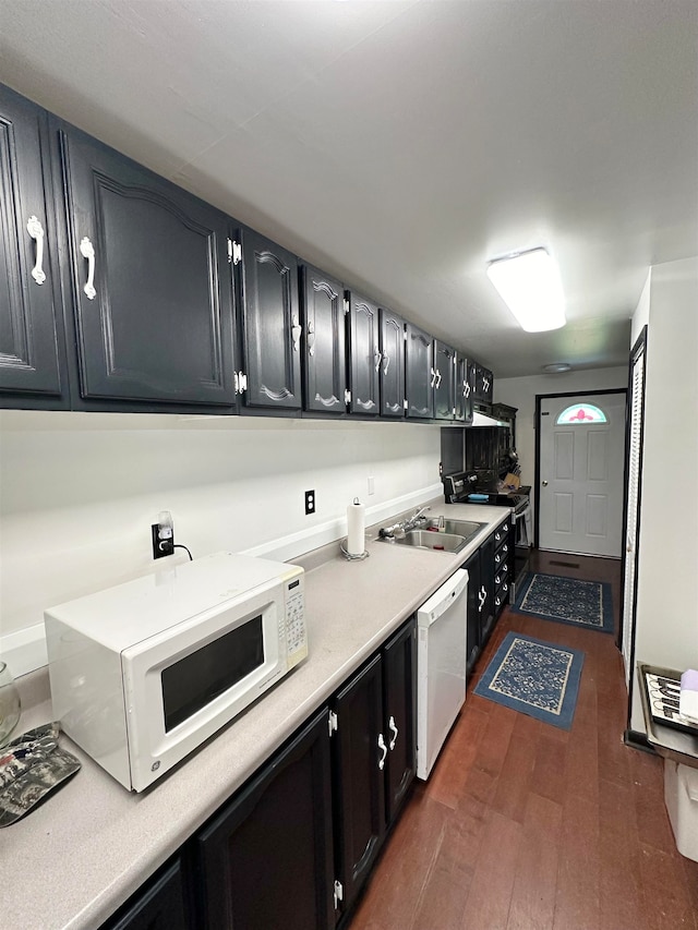 kitchen featuring white appliances, sink, and dark hardwood / wood-style flooring