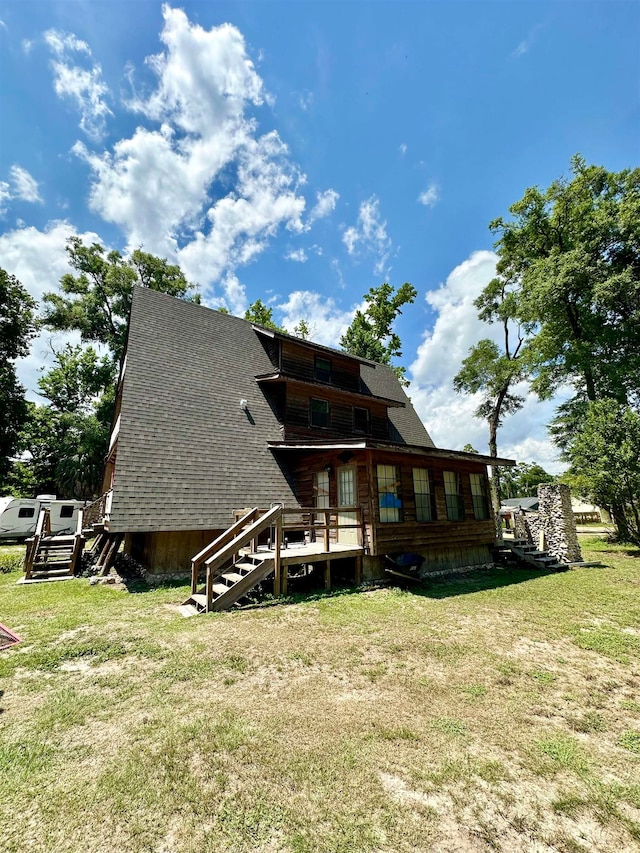 back of property featuring a lawn and a deck