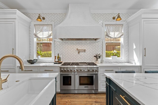 1216 Mitchell Ave, Tallahassee, FL 32303 - kitchen featuring a sink, crown molding, double oven range, white cabinetry, and custom range hood