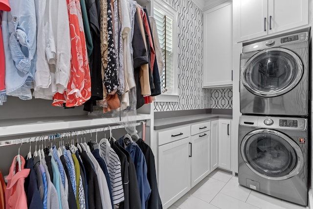 1216 Mitchell Ave, Tallahassee, FL 32303 - laundry room featuring light tile patterned flooring, cabinet space, stacked washer and clothes dryer, and wallpapered walls