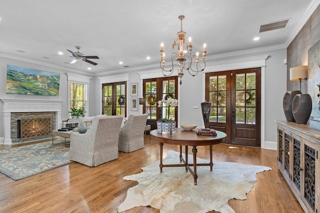 1216 Mitchell Ave, Tallahassee, FL 32303 - living area with wood finished floors, ceiling fan with notable chandelier, a fireplace with flush hearth, french doors, and visible vents
