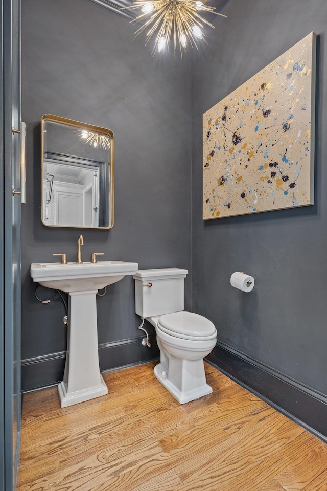 1216 Mitchell Ave, Tallahassee, FL 32303 - half bathroom featuring wood finished floors, toilet, baseboards, and a notable chandelier