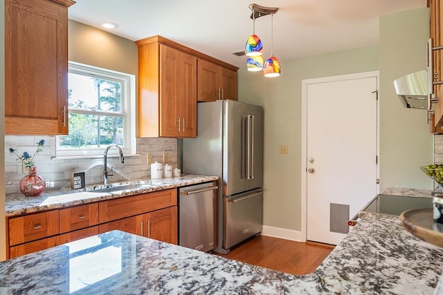 696 Lupine Ln, Tallahassee, FL 32308 - kitchen with stainless steel appliances, dark wood-style floors, brown cabinetry, tasteful backsplash, and light stone counters