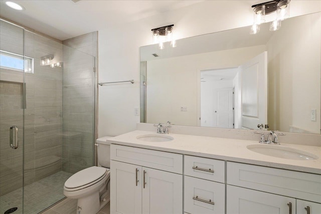 bathroom featuring vanity, toilet, and a shower with door