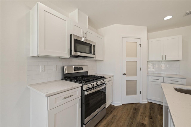 kitchen with white cabinetry, appliances with stainless steel finishes, and backsplash