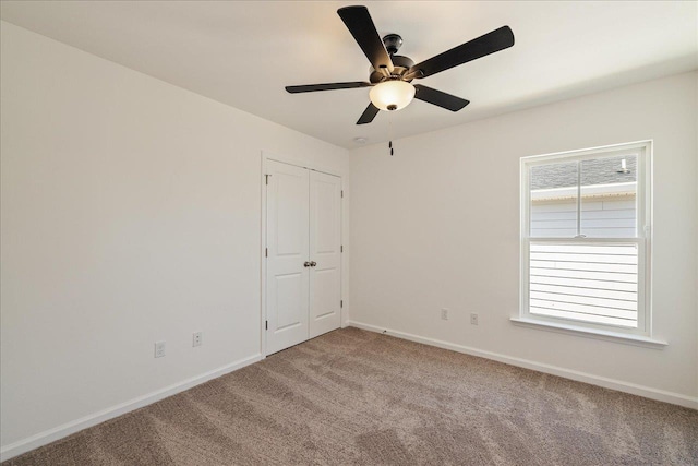 spare room with ceiling fan and carpet