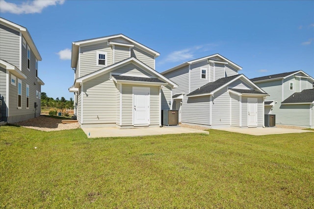 rear view of property featuring a lawn, a patio, and central air condition unit