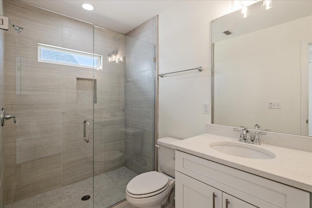 bathroom featuring toilet, vanity, and walk in shower