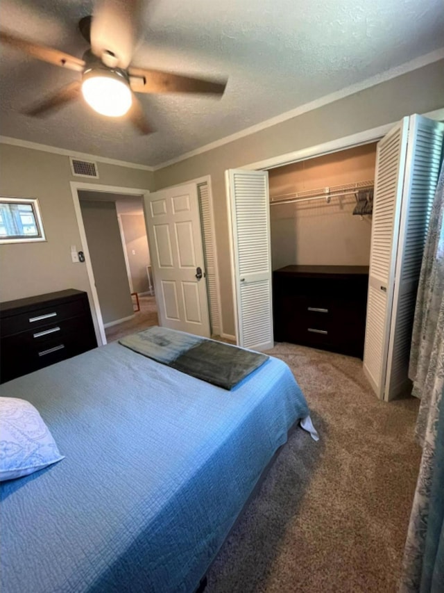 bedroom with carpet flooring, a textured ceiling, ceiling fan, crown molding, and a closet