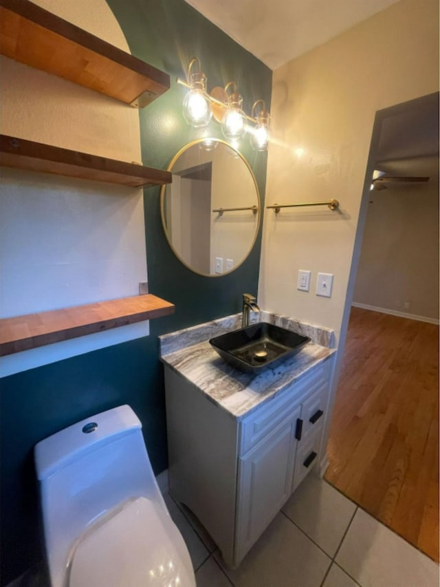 bathroom with hardwood / wood-style floors, ceiling fan, vanity, and toilet