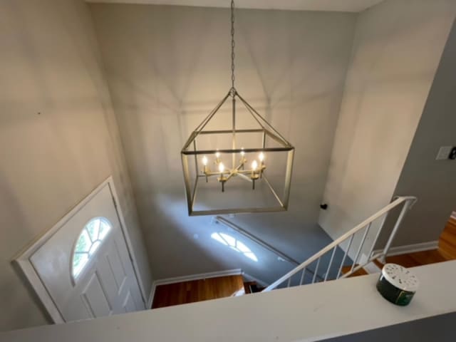 foyer entrance with a notable chandelier and hardwood / wood-style flooring