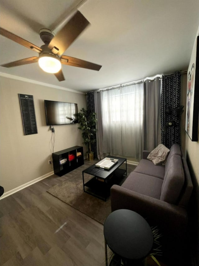 living room featuring dark hardwood / wood-style flooring, ornamental molding, and ceiling fan
